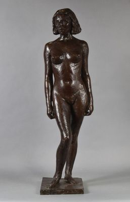 a bronze statue of a woman standing on top of a wooden base