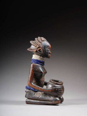 un gros plan sur la statue d'une personne tenant un bol