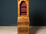 an antique wooden bureau with a red velvet top