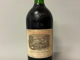 an old bottle of wine sitting on top of a white table