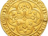 a close up of a gold coin with a cross on it