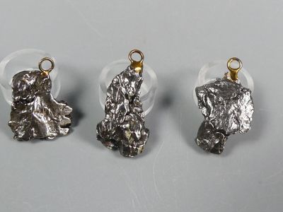 three pieces of silver metal with a small dog on it