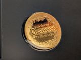 a gold coin with a picture of a wheat field on it