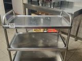 a metal cart with three trays on it in a kitchen