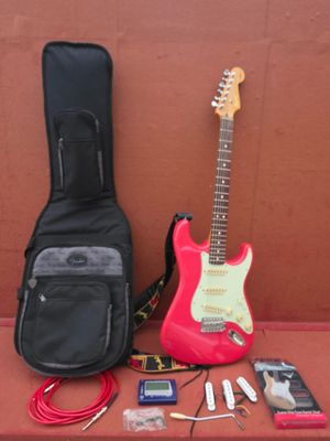 une guitare, un étui à guitare, une guitare et d'autres instruments de musique posés sur une table