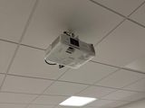 a ceiling mounted projector in the middle of a room