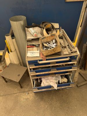 a cart with tools on top of it next to a chair