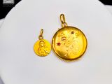 une pièce d'or et une pierre rouge sur une assiette blanche