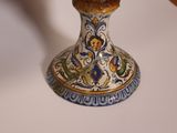 a vase with a bird on it sitting on a table