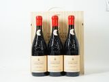 trois bouteilles de vin dans un coffret en bois sur une surface blanche