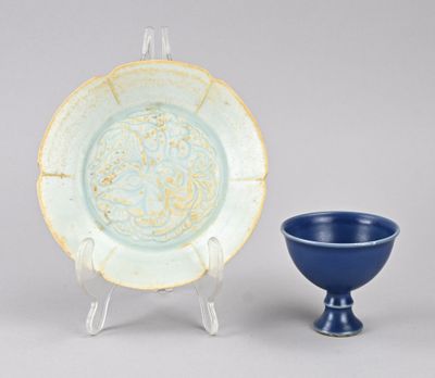un bol bleu et une assiette bleue posés sur un présentoir