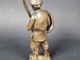 a statue of a man holding a knife and a shield