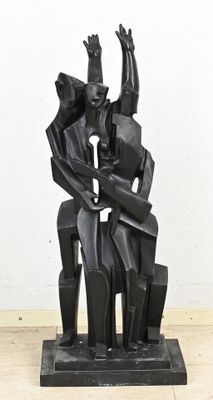 statue représentant un homme et une femme assis sur une chaise, les mains en l'air
