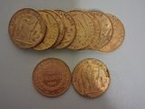 plusieurs pièces d'or empilées les unes sur les autres sur une surface blanche