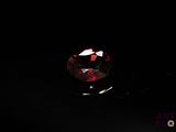 an image of a close up of a red diamond on a black surface