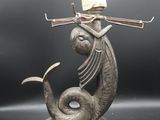 une image représentant une statue de poisson surmontée d'une lampe