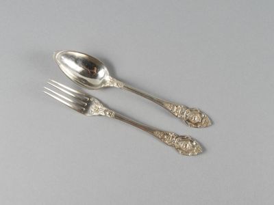 deux cuillères et une fourchette en argent sur une table