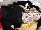 a pile of clothes sitting on top of a bed