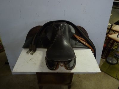 a horse saddle and a pair of shoes sitting on a table