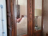 une grande armoire en bois surmontée d'un miroir
