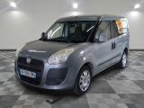 une photo d'une petite camionnette grise garée dans un garage