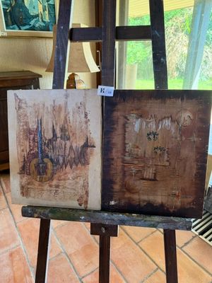 un chevalet sur lequel sont posés deux tableaux, dans une pièce