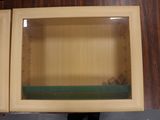 a wooden cabinet with a glass door on top of it