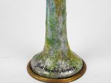 a green vase with a gold base on a white background