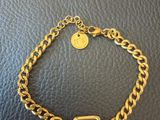 a gold bracelet with a black stone on it