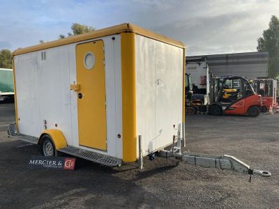 une photo d'une remorque jaune et blanche dans un parking