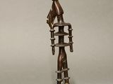 bronze sculpture of a woman on a chair with a bird perched on top of it