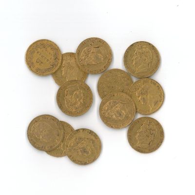 quelques pièces d'or posées sur une surface blanche, sur fond blanc