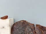 deux morceaux de chocolat posés sur un plan de travail, à côté d'une tablette de chocolat