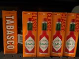 several bottles of tabasco sauce are on a shelf in a store