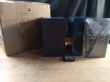 two speakers and a remote on a table next to a box