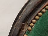 an antique wooden chair with a green velvet upholstered seat