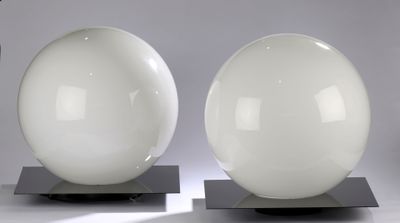 pair of white glass lamps on metal bases on a gray background