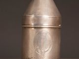 an old silver coffee grinder sitting on top of a wooden table