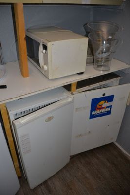 two microwaves and a dishwasher sitting on a shelf in a kitchen