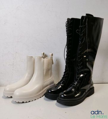 une paire de bottes noires et blanches posées l’une à côté de l’autre sur une table