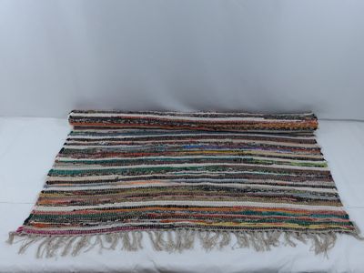 un gros plan d'un tapis multicolore posé sur une surface blanche