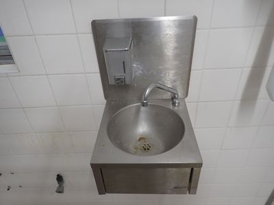 un lavabo en acier inoxydable dans des toilettes publiques