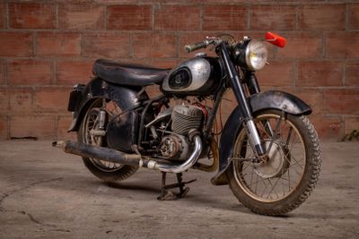a black motorcycle parked in front of a brick wall