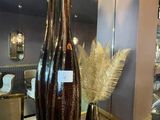 a large vase with feathers in it on a table