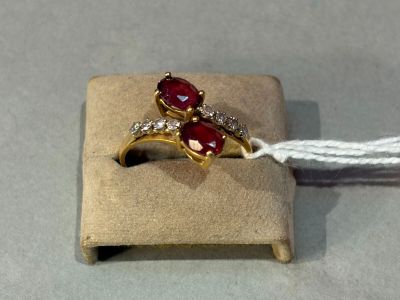 a gold ring with two red stones on it