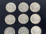 a close up of a bunch of silver coins on a black surface