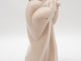 figurine of a man in a white robe and hat with his arms crossed