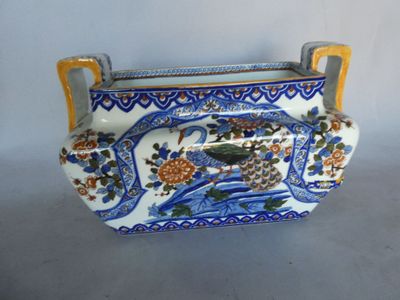 a blue and white vase with a bird and flowers on it
