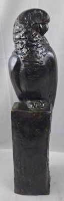 statue of a bird sitting on top of a wooden block