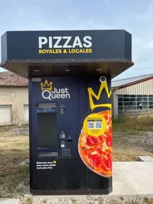 un distributeur automatique sur lequel est posée une pizza